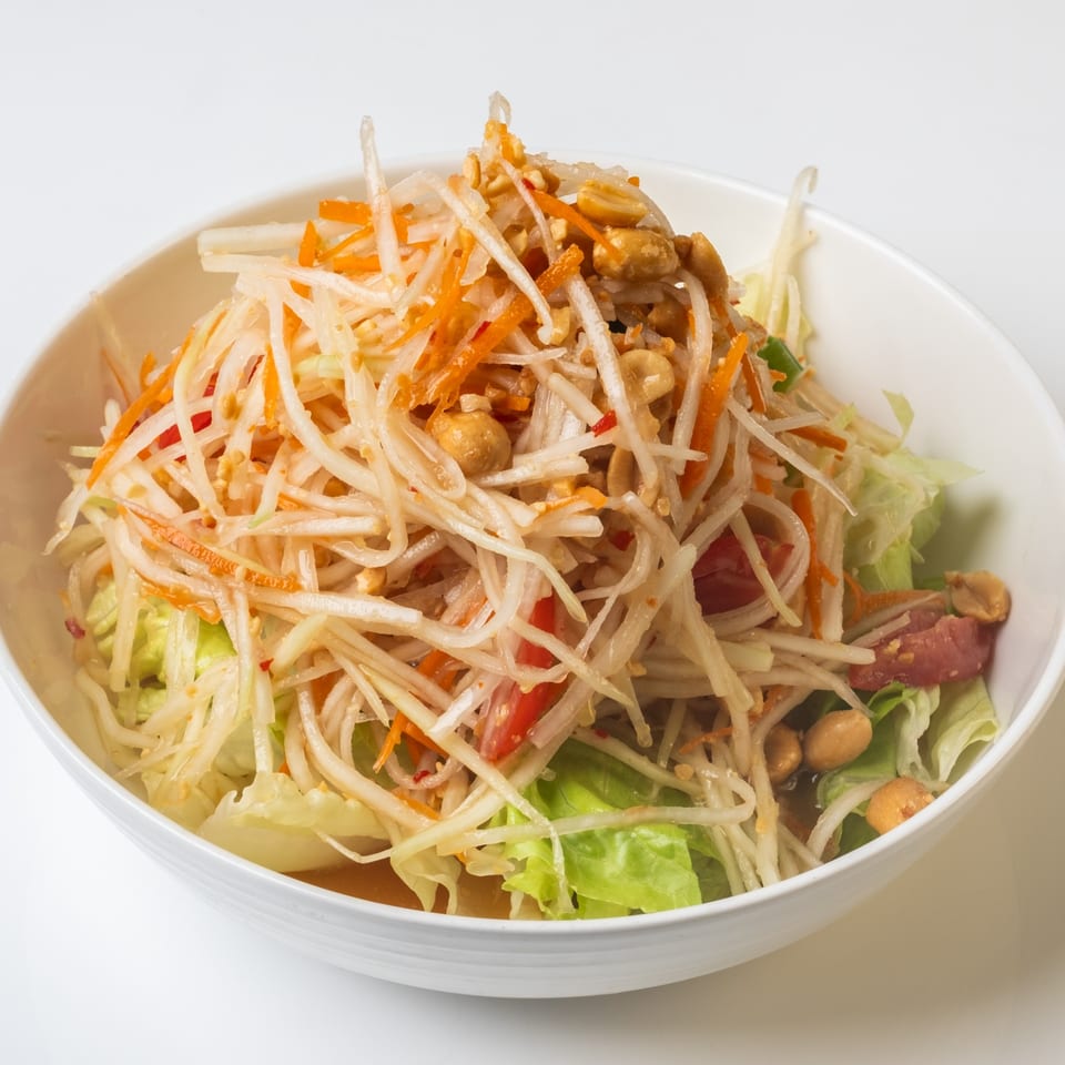 KorKai Thai Restaurant's Som Tum, a vibrant papaya salad with shredded carrots, peanuts, and lettuce.